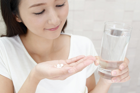 コラーゲンサプリメントを飲む女性の画像