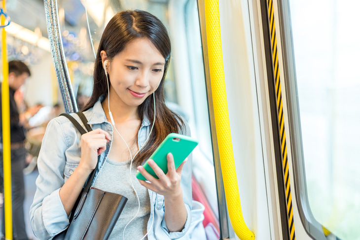 電車で立つ女性の画像