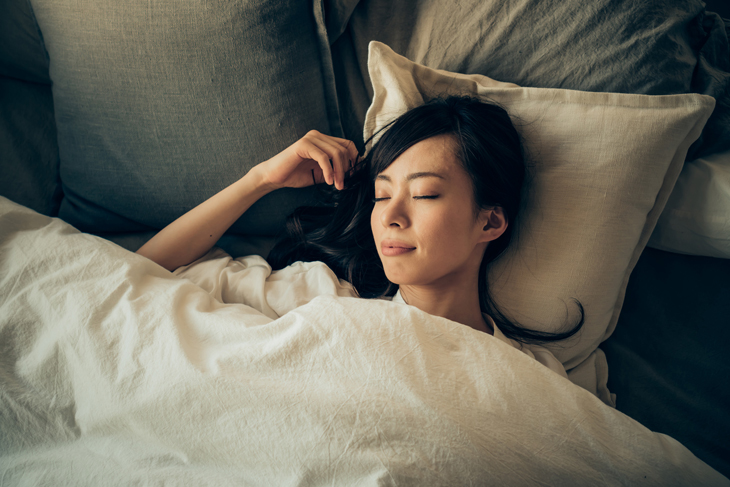 高い枕で寝る女性の画像